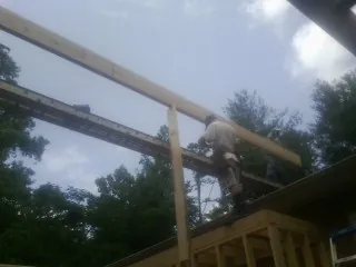 Carpenter setting a ridge beam over a new addition frame — Ice Dam Removal by Roofing Brothers in Belle Mead