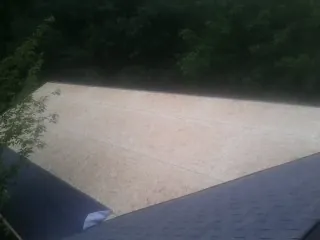 New OSB roof sheathing installed beside an existing shingle roof in Belle Mead
