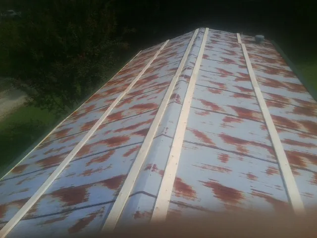 Rusted metal roof panels with new wood purlins before replacement — Storm Damage Roof Repair in Belle Mead by Roofing Brothers