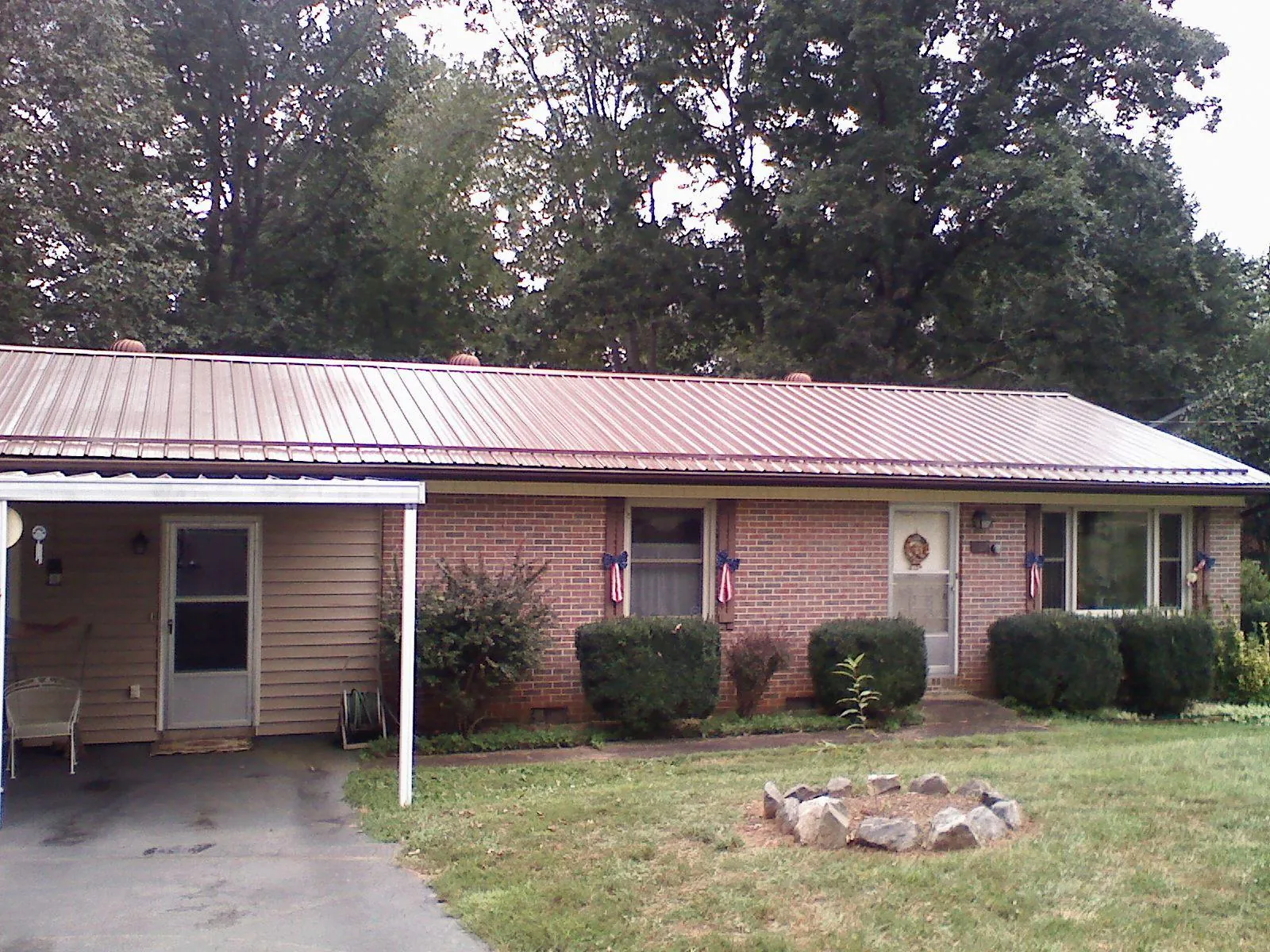 Bronze metal roof and carport on a brick ranch home — Roof Repair work by our crew in Belle Mead